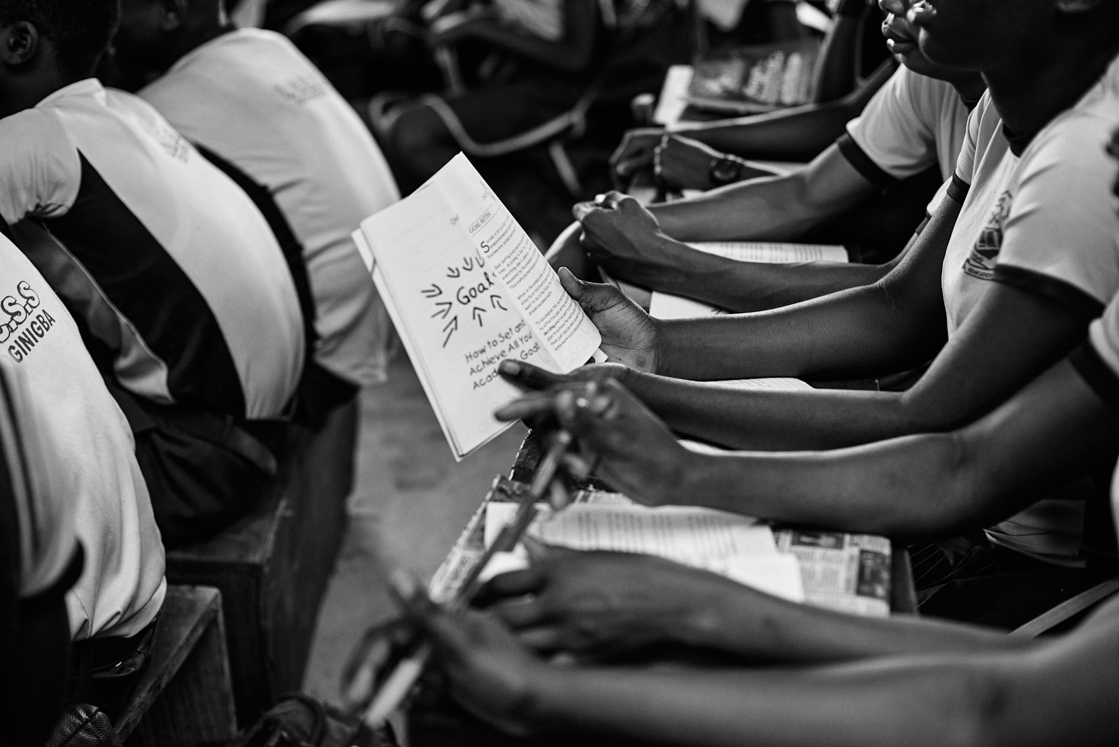 Students holding paper booklets and handouts